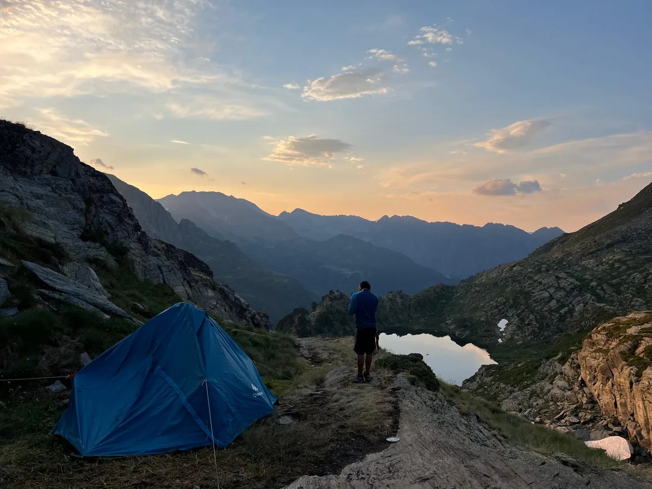 Una tenda plantada al costat d’un estany al capvespre
