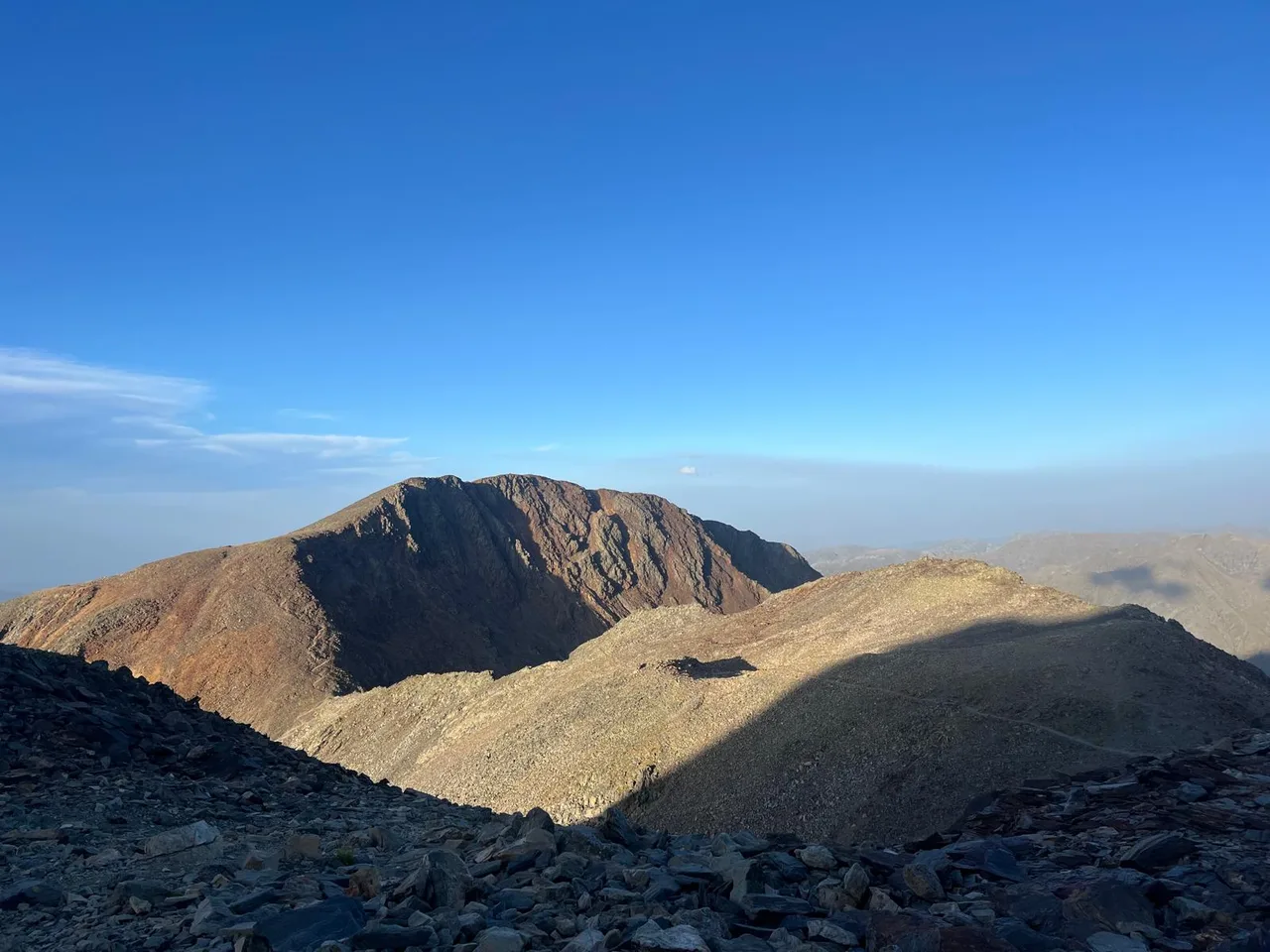 Un cim rocós i els seus vessants sota un cel blau