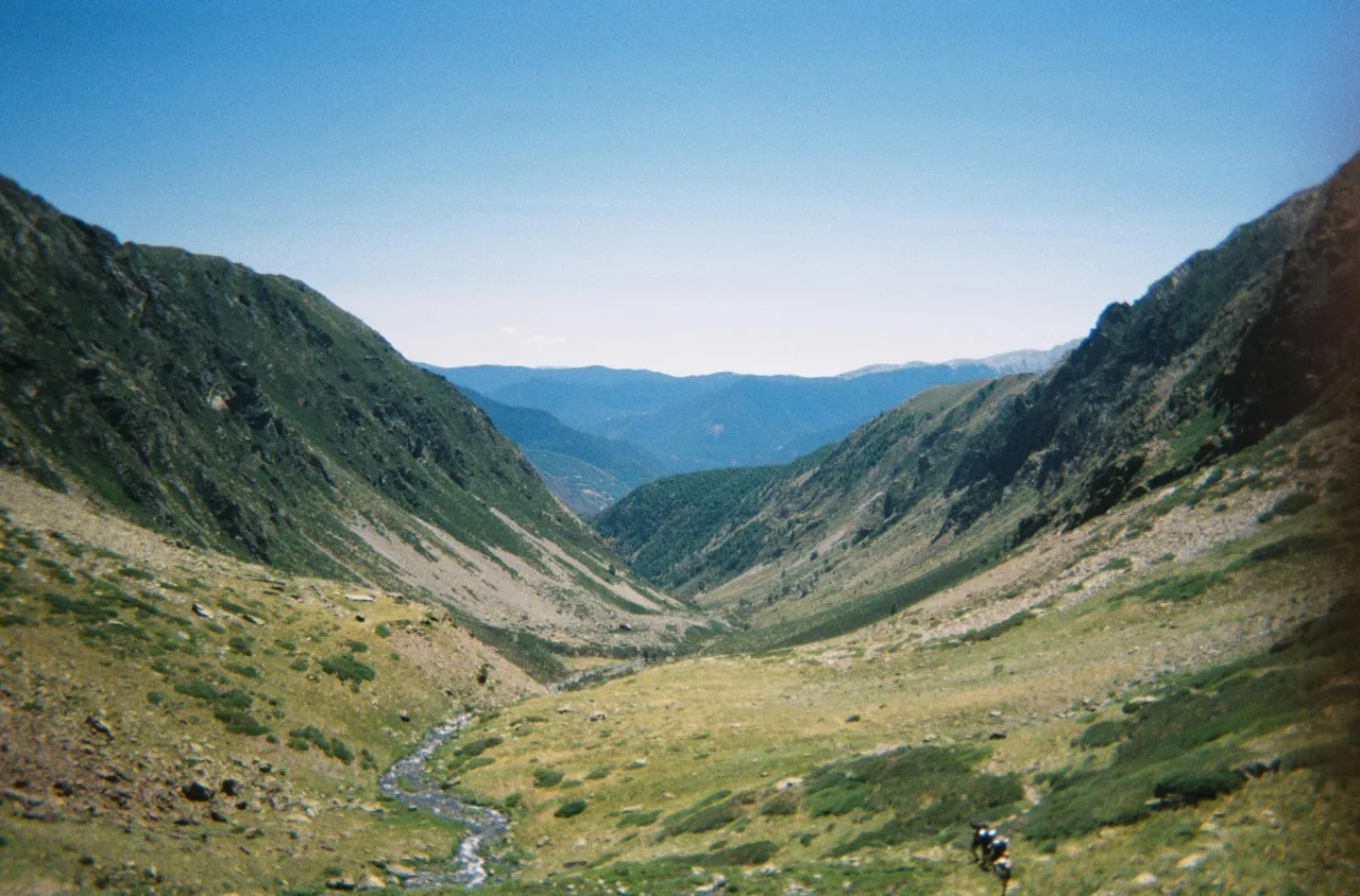 Una vall verda s’obre entre vessants d’alta muntanya